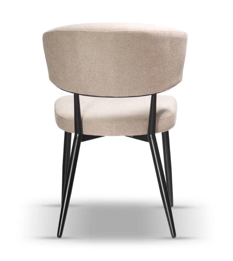 May include: A beige upholstered dining chair with a black metal frame and angled legs.