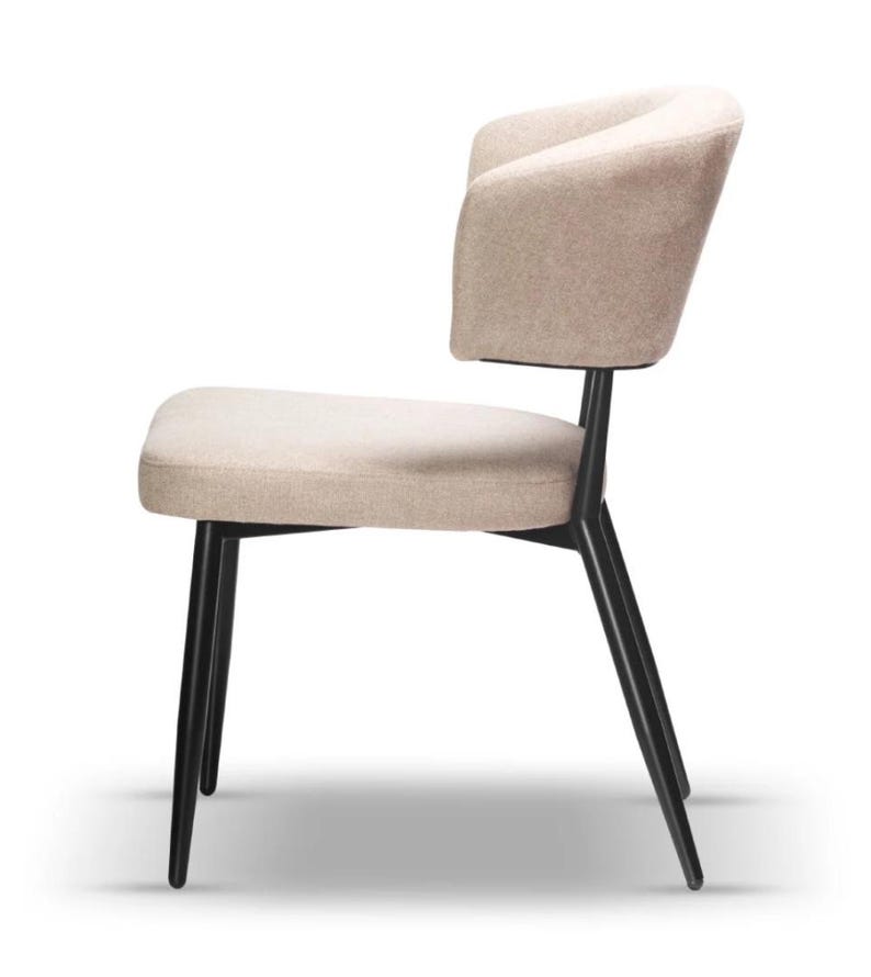 May include: A beige upholstered dining chair with a curved back and black metal legs.