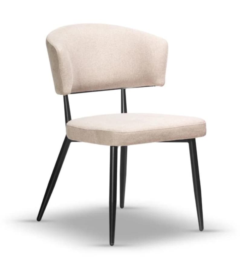 May include: A beige upholstered dining chair with a black metal frame. The chair has a curved back and a slightly angled seat.