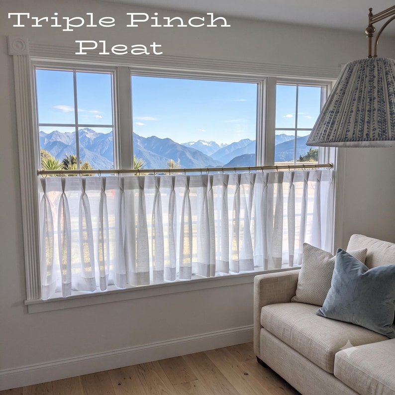 Puede incluir: Cortinas de caf&eacute; blancas y semitransparentes con cabezal de triple pliegue pellizcado colgadas de una barra de lat&oacute;n en una ventana. El texto Triple Pinch Pleat es visible en la esquina superior izquierda. Las cortinas tienen una textura.