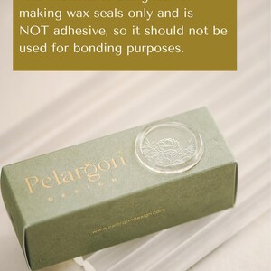May include: A green box with the text "Pelargon Design" and a clear wax seal stamp. The box is sitting on a white surface with several clear wax sticks.