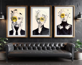 May include: Three framed art prints featuring stylized portraits of a woman with yellow accents and fish motifs. The artwork is in a wooden frame, and the woman is wearing a black turtleneck. The prints are displayed above a black leather sofa.