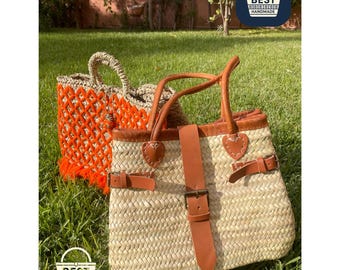 May include: Two handmade straw tote bags on green grass. One bag is natural with brown leather straps and buckles. The other is orange with a woven design and fringe. The bags have the text "BEST HANDMADE".