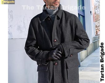 May include: A charcoal gray wool coat with a classic design. The coat features a collared neckline, button closures, and two front pockets. The model is wearing black leather gloves. The text "The Tartan Brigade" is visible.