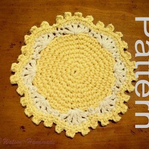 Pode incluir: Um descanso de copo de crochê amarelo e branco com uma borda festonada. O descanso de copo é feito com um design circular e tem uma borda delicada e rendada.