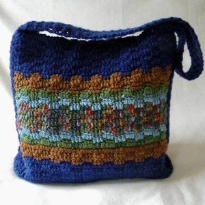 May include: A blue crocheted shoulder bag with a brown, green, and blue patterned stripe.