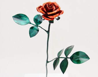 Pequeña escultura de metal con rosa de cobre naranja