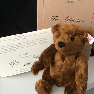 Könnte beinhalten: Ein dunkelbrauner Teddybär, 27 cm groß, mit schwarzer Nase und braunen Pfoten. Der Bär ist Teil einer limitierten Auflage von 2.000 Stück. Die Verpackung enthält den Text "The Artist's bear" und "EXCLUSIVELY FOR QVC, UK."