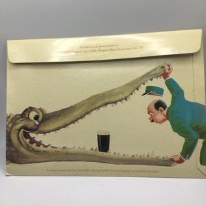 Puede incluir: Anuncio vintage de Guinness con una ilustraci&oacute;n de dibujos animados. Un hombre con un traje verde interact&uacute;a con un gran cocodrilo, con una pinta de Guinness entre las mand&iacute;bulas del cocodrilo. El fondo es de color beige claro.
