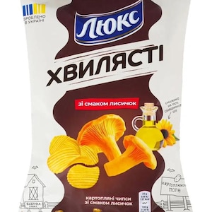 Może przedstawiać: Opakowanie chipsów ziemniaczanych w brązowo-białym wzorze. Opakowanie zawiera nazwę marki "Люкс" i słowa "ХВИЛЯСТІ" dużymi literami. Opakowanie przedstawia również obrazy złotych chipsów, kurek i oleju słonecznikowego.