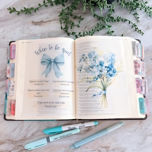 May include: An open Bible with colorful tabs, featuring a page titled When to be quiet with a blue bow illustration and a blue floral bouquet. Below the book are three light blue pens, including a Sharpie S-Note and a Bic highlighter.