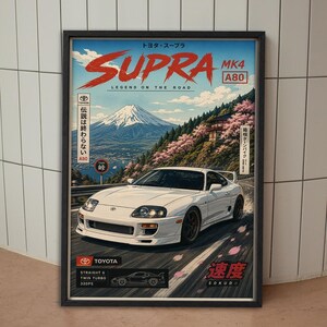 Puede incluir: Un póster enmarcado que muestra un Toyota Supra MK4 A80 blanco en una carretera de montaña. El fondo presenta el monte Fuji y flores de cerezo. El texto incluye SUPRA MK4 A80, LEGEND ON THE ROAD, TOYOTA, STRAIGHT 6 TWIN TURBO 320PS y SOKUDO.