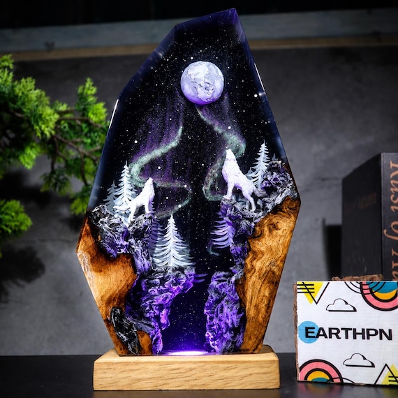 A handmade epoxy resin lamp where a howling wolf silhouette glows against a full moon embedded in real wood — the kind of moody, one-of-a-kind night light you genuinely can't find at Target.