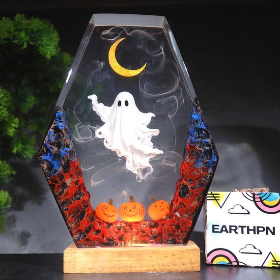 A ghostly spooky diorama cast in glowing resin — cute ghost, crescent moon, and pumpkins in one hand-poured lamp that works year-round for Halloween lovers.