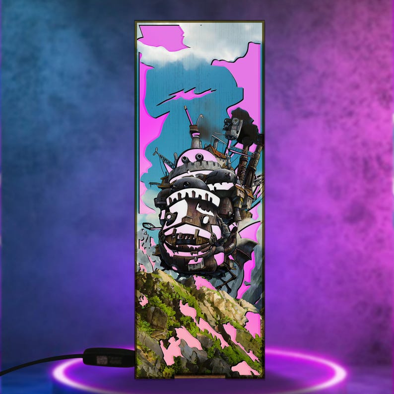 May include: A rectangular lamp featuring a colorful illustration of a moving castle, set against a pink and blue sky. The castle is detailed with various mechanical elements and is positioned above a green, rocky landscape. The lamp has a black cord and a switch.
