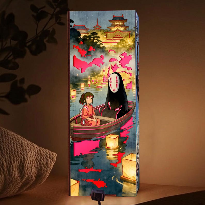 K&ouml;nnte beinhalten: Rechteckige Lampe mit einer Illustration aus dem Zeichentrickfilm Spirited Away. Das Kunstwerk zeigt ein M&auml;dchen und eine Figur in einem Boot auf einem Fluss mit schwimmenden Laternen und einem Geb&auml;ude im japanischen Stil im Hintergrund.