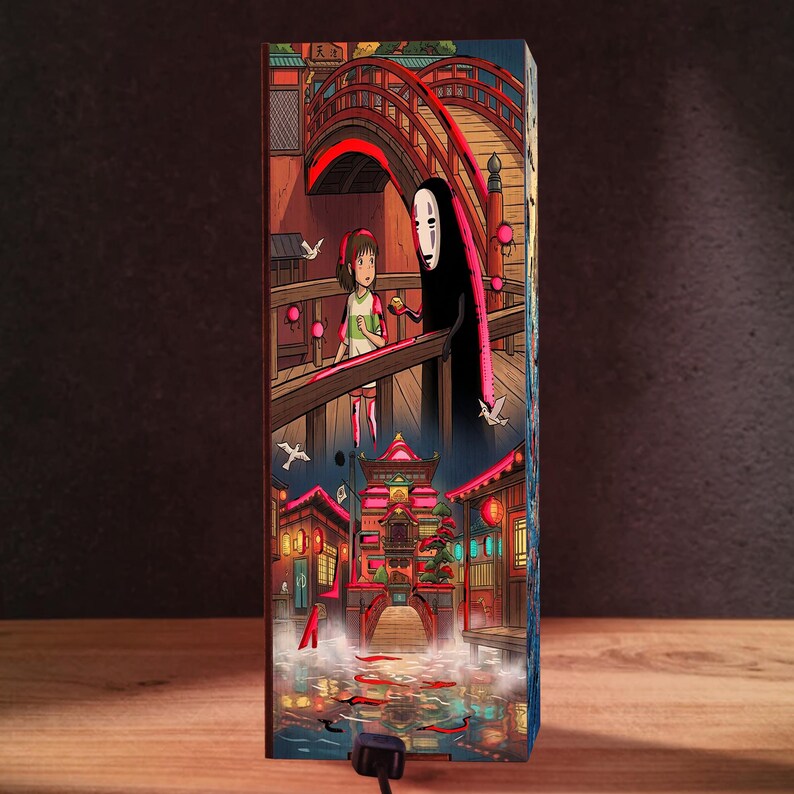 May include: A rectangular vertical lamp featuring a colorful illustration of a young person with brown hair and a black-cloaked figure with a white mask standing on a wooden bridge, with a detailed bathhouse scene and red koi fish in the water below.