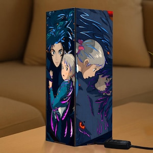 May include: A rectangular lamp featuring anime-style artwork. The lamp's design showcases characters with blue and gray hair, set against a dark blue background with purple accents. The lamp is on a wooden surface.