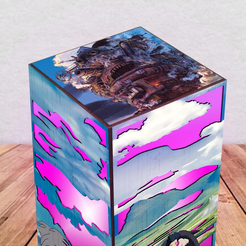May include: A wooden box featuring a colorful illustration of a fantastical airship against a cloudy sky. The box has a blue and pink design with a cartoonish style, and is set on a wooden surface.