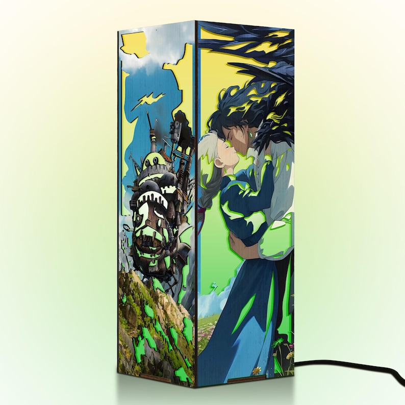 May include: A rectangular lamp featuring artwork from an animated film. The lamp's sides display colorful illustrations of a castle, a couple embracing, and a landscape with green and blue hues. A black power cord extends from the base.