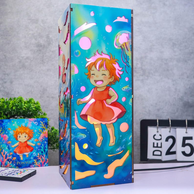 May include: A rectangular wooden lamp featuring a vibrant underwater scene with a cartoon character in a red dress surrounded by jellyfish, fish, and bubbles. The design is illuminated with warm light, highlighting the blue and orange color palette.