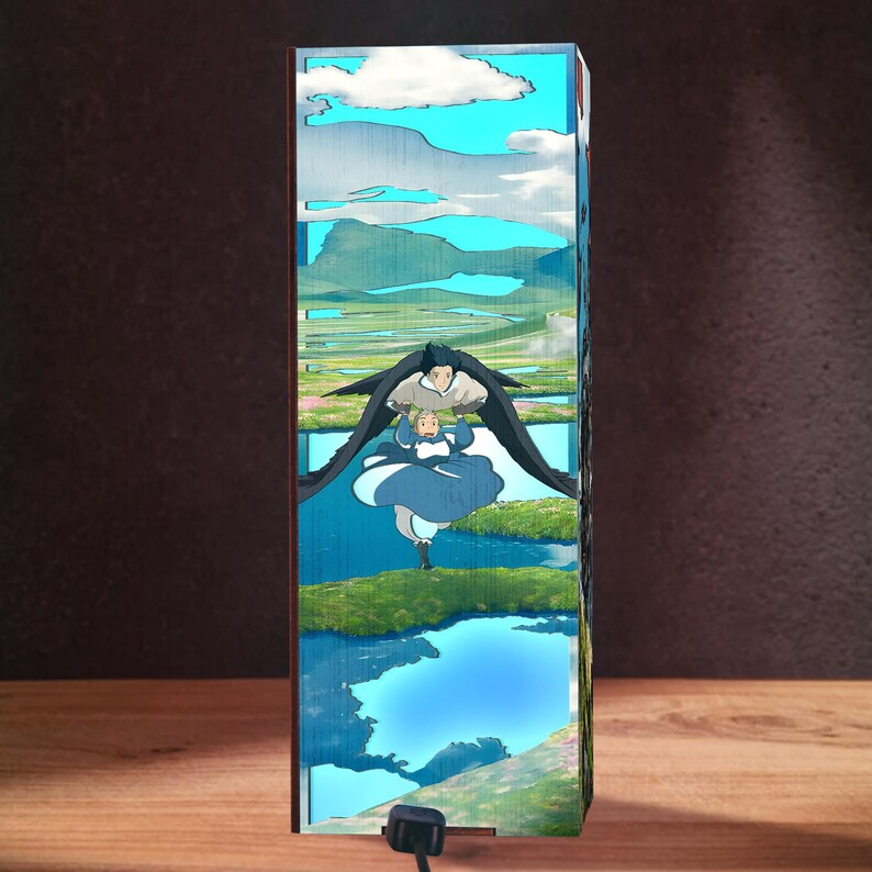 May include: A rectangular night light featuring a scene from an animated film. The artwork depicts two characters flying over a landscape with blue skies, clouds, and water. The light has a black power cord.