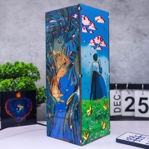May include: A rectangular wooden lamp with a colorful anime-style illustration. The artwork features figures in a field with butterflies, clouds, and a couple. The lamp has a blue and green color scheme, with a remote control visible.
