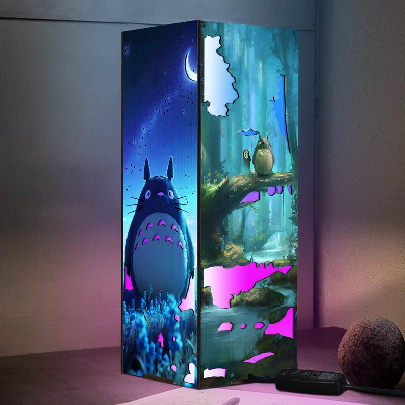 Może przedstawiać: Dekoracyjny, podświetlany panel z grafiką z filmu animowanego M&oacute;j sąsiad Totoro. Panel przedstawia postać Totoro na tle gwiaździstego nieba i sceny leśnej z innymi postaciami. Panel ma kształt prostokątny i jest podświetlany r&oacute;żowymi i niebieskimi światłami.