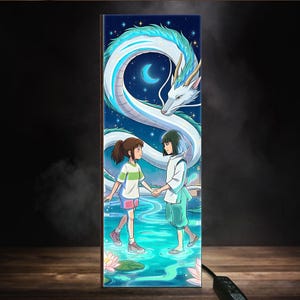 Puede incluir: Una impresi&oacute;n art&iacute;stica vertical que representa una escena de una pel&iacute;cula de animaci&oacute;n. Dos j&oacute;venes se toman de la mano en un entorno acu&aacute;tico sereno, con un gran drag&oacute;n blanco y turquesa sobre ellos contra un cielo estrellado. La obra de arte tiene un tema de fantas&iacute;a.