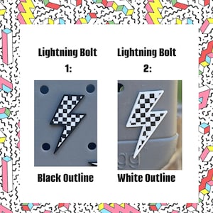 May include: Two images of a checkered lightning bolt charm. The first image shows the charm with a black outline on a gray background. The second image shows the charm with a white outline on a gray background. The text "Lightning Bolt 1: Black Outline" is below the first image. The text "Lightning Bolt 2: White Outline" is below the second image.