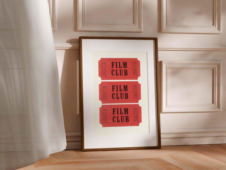 May include: A framed print with three red tickets that say "Film Club" in black text. The tickets are arranged vertically in a row.