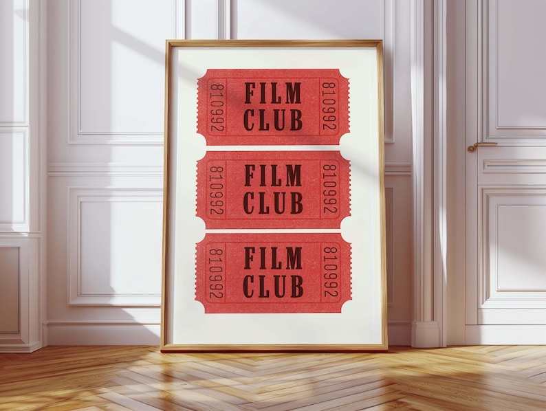 May include: Three red tickets with the text "FILM CLUB" and the number "810992" printed on them. The tickets are framed and hanging on a white wall.