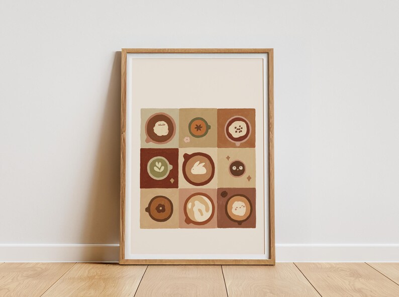 May include: A framed art print displaying a grid of nine coffee cup designs. Each cup features a unique latte art design, such as a flower, bunny, and other shapes. The colour scheme includes browns, tans, and greens.