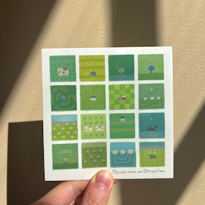 May include: A square art print featuring a grid of sixteen small illustrations in various shades of green. Each square depicts a different landscape scene with elements like trees, houses, animals, and flowers. The text purple.times.art Purple Times is printed at the bottom right corner.