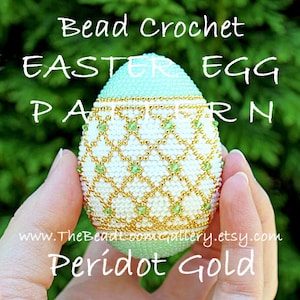 Może przedstawiać: Wzór na haftowany koralikami, wielkanocny jajko w kolorze perydotu i złota. Jajko jest białe z geometrycznym wzorem z złotych i zielonych koralików.