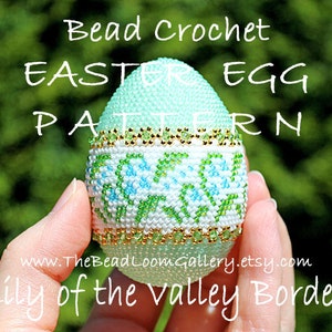 以下が含まれることがあります： 緑、白、金色のビーズでできたイースターエッグで、スズランの縁取りが施されています。卵は手で持たれています。画像には「Bead Crochet Easter Egg Pattern Lily of the Valley Border」というテキストが表示されています。