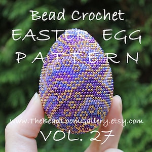 以下が含まれることがあります： 紫、青、金色のカラーパレットでビーズで飾られたイースターエッグのクロシェパターン。卵は手で持たれており、テキスト「Bead Crochet Easter Egg Pattern Vol. 27」が表示されています。