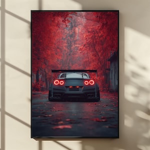 Puede incluir: Impresión enmarcada de un coche deportivo negro con luces traseras rojas, en una carretera bordeada de árboles rojos. La obra de arte tiene una atmósfera melancólica, destacando el diseño del coche. El marco es negro.