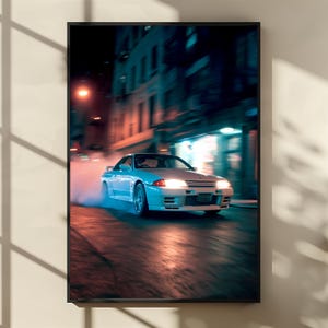 Könnte beinhalten: Gerahmter Druck eines weißen Sportwagens, der nachts auf einer nassen Straße driftet. Die Scheinwerfer des Autos sind eingeschaltet, und Rauch steigt von den Reifen auf. Der Hintergrund zeigt verschwommene Gebäude und Straßenlaternen.
