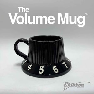 May include: Black ceramic mug designed as a guitar volume knob, with white numbers 4 to 8. The mug features a handle and the text "The Volume Mug" in white. The brand name "Chibson" is at the bottom.