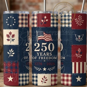 Op de afbeelding: Een cilindrische beker met een metalen rietje met een patriottisch patchworkontwerp in rood, wit en blauw. Het middenpaneel toont een Amerikaanse vlag, de tekst 250 YEARS OF FREEDOM en de jaren 1776-2026 met ster- en bladmotieven.