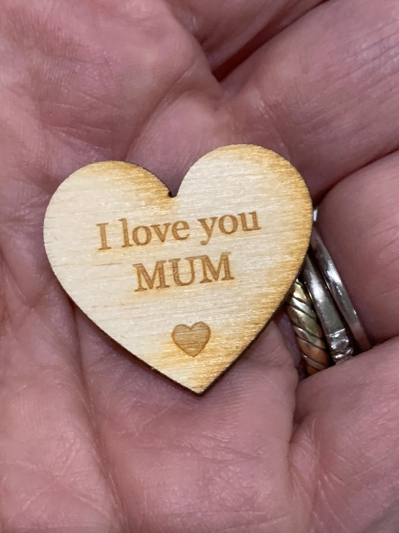 May include: Wooden heart-shaped ornament with the text "I love you MUM" engraved on it.