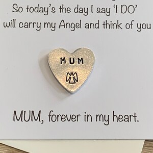 May include: A white card with the text "So today's the day I say 'I DO' will carry my Angel and think of you MUM, forever in my heart."  A silver heart charm with the word "MUM" and an angel design is attached to the card.
