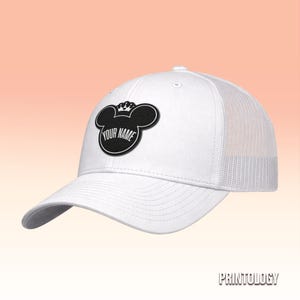May include: A white baseball cap with a mesh back and a black patch on the front. The patch is shaped like a mouse head with a small crown on top and features the text YOUR NAME in white capital letters centered within the black silhouette.