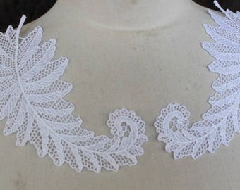 Può includere: Due applicazioni di pizzo bianco a forma di foglie di felce. Le applicazioni sono delicate e intricate, con un design floreale.