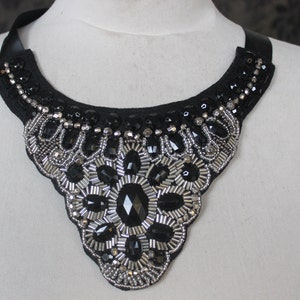May include: A black fabric choker necklace with silver and black beads and rhinestones.