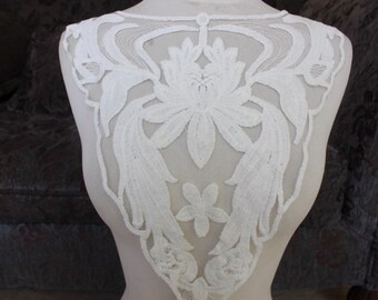 White  color embroidered applique 5 1/2 inches wide at the neck 3 inches wide at the shoulder 13 inches long center down