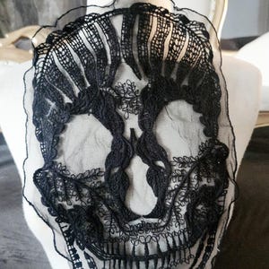 May include: Black lace skull applique for sewing or crafting projects. The skull is detailed with intricate lacework and has a delicate, ethereal look.