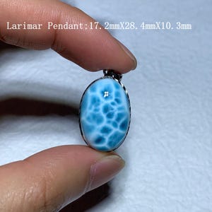 May include: Larimar pendant with a silver-colored setting. The oval-shaped pendant features a blue and white pattern, with dimensions of 17.2mm x 28.4mm x 10.3mm. The text "Larimar Pendant" is visible in the image.