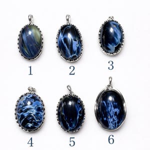 Puede incluir: Seis colgantes ovalados con engastes plateados y piedras preciosas azules. Las piedras preciosas presentan patrones y tonos de azul únicos. El texto dice "You Will Receive EXACT Stone Shown" y "Model Image Is For Wearing Reference Only".